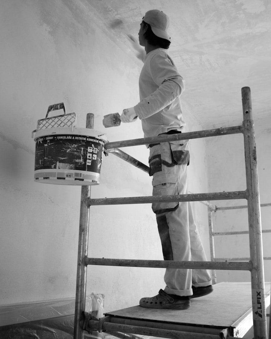 Painter on a ladder rolling a wall
